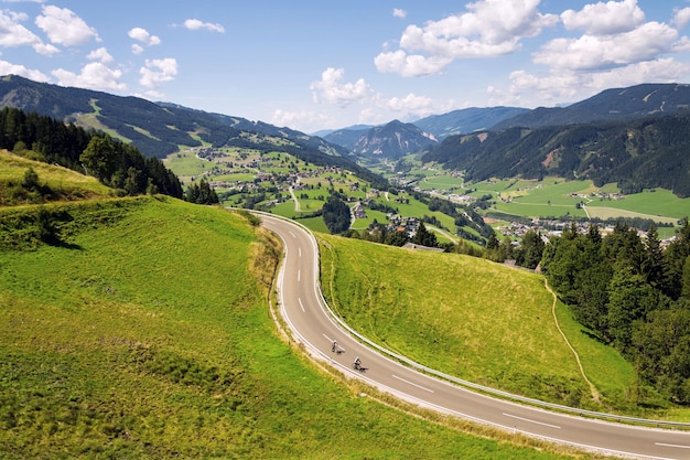 Ciclistas no vale com a cidade de Schladming na Estíria Áustria