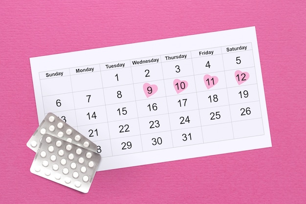 Ciclo menstrual feminino. Conceito de ciclo menstrual feminino. Calendário dos dias da mulher em uma rosa, pílulas hormonais. Saúde da Mulher