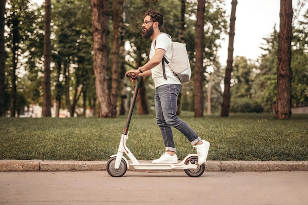 Cidadão moderno viajando de scooter elétrica ecológica na calçada