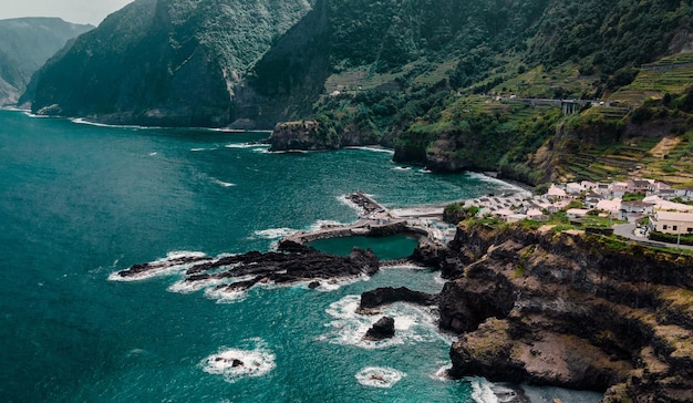 Cidade com piscinas naturais na costa do oceano em penhasco Madeira Portugal Foto aérea de drones