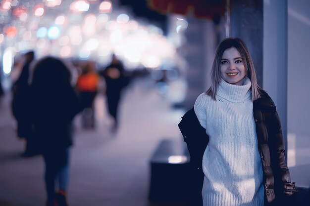 Cidade de compras de Natal, jovem modelo de compras de presentes noturnos, venda sazonal, noite de inverno fora da cidade