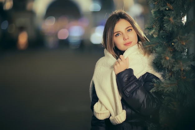 Cidade de compras de Natal, jovem modelo de compras de presentes noturnos, venda sazonal, noite de inverno fora da cidade