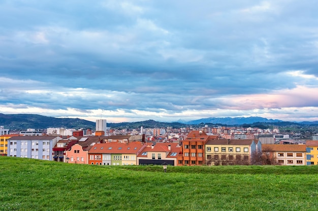 Cidade de Gijon ao lado das altas montanhas dos Picos de Europa em um dia nublado e chuvoso