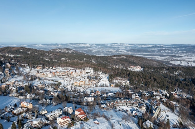 Cidade de inverno entre a floresta nas montanhas Vista da paisagem de inverno de um drone Karpacz Polônia