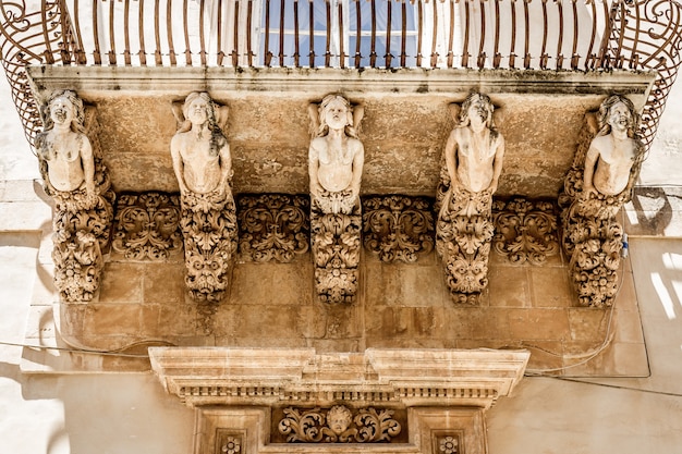 Foto cidade de noto na sicília, a maravilha barroca - patrimônio da unesco. detalhe da varanda do palazzo nicolaci, expressão máxima do barroco siciliano.