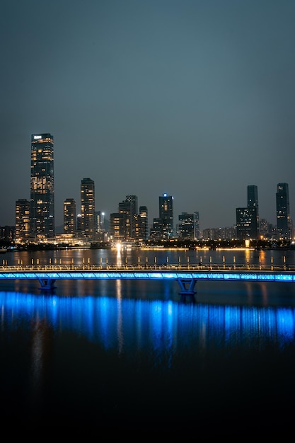 Foto cidade iluminada à beira-mar em frente a um edifício de bambu na área da baía de shenzhen