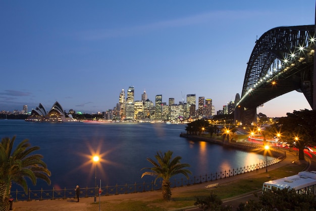 Cidade iluminada e ponte do porto de Sydney à noite