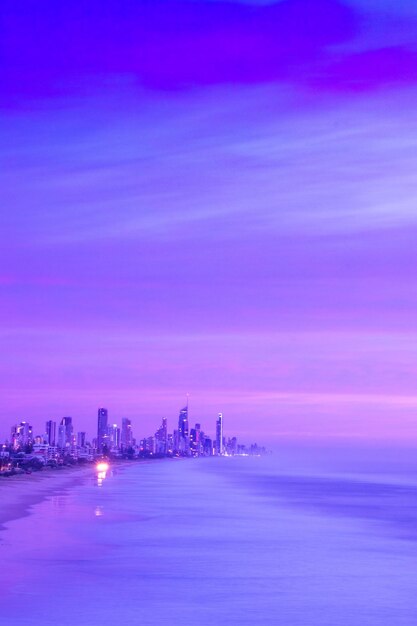 Cidade iluminada pelo mar contra o céu à noite