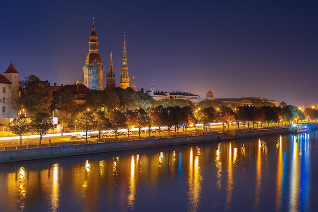 Cidade velha de riga e rio daugava à noite catedral de riga e ponte ferroviária da igreja de são peter e