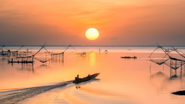 Cielo del amanecer con pescador en barco