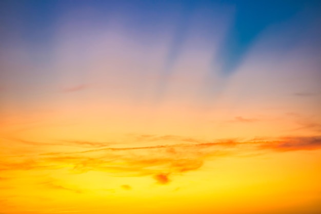 Cielo del atardecer con nubes azules rojas y rayos de sol