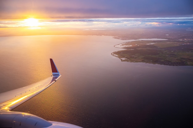 Cielo del atardecer en la ventana del avión sobre Copenhague, Dinamarca en el vuelo del viernes por la noche