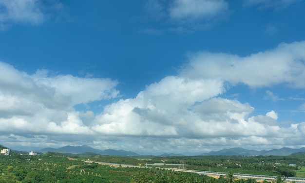 Cielo azul al aire libre, nubes blancas y paisajes rurales.