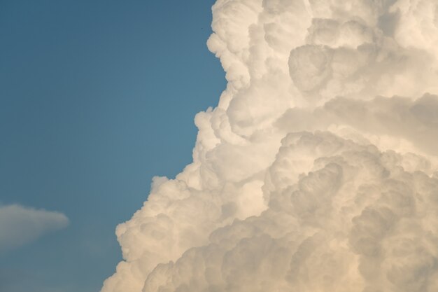 Cielo azul al atardecer con textura de raras y hermosas nubes cúmulos vespertinas a la luz del sol poniente para el fondo del diseñador