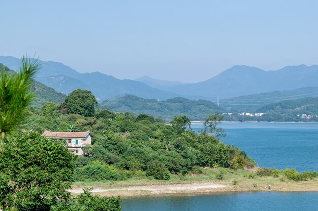 Bajo el cielo azul, hay bosques a ambos lados del lago.