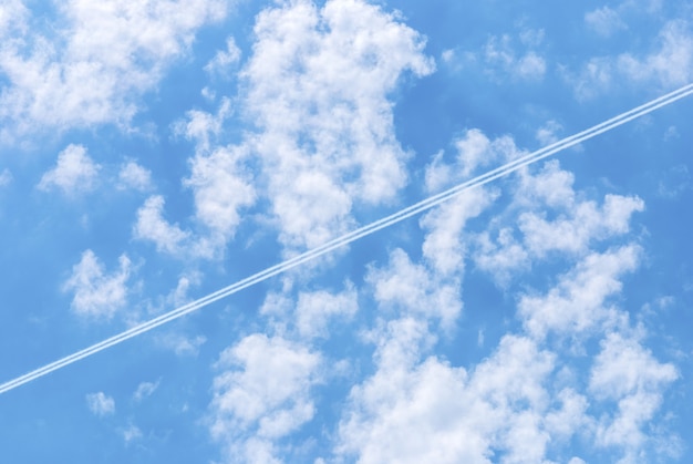 Cielo azul con nubes y estelas de condensación