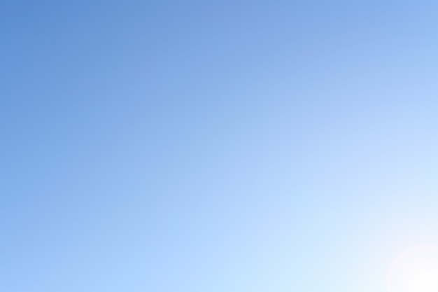 Cielo azul con nubes y luz solar.