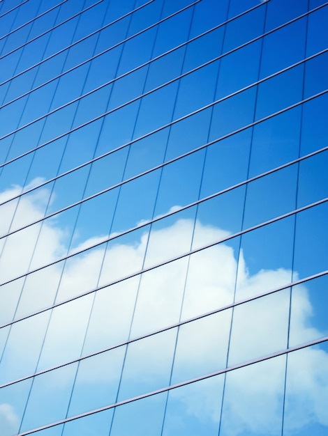 Cielo azul y nubes que reflejan en un edificio con vidrio reflejado