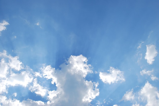 Un cielo azul con nubes y rayos de sol.