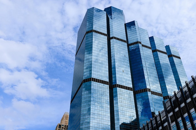El cielo azul y las nubes se reflejan en el cristal de los edificios comerciales de oficinas en el centro de la ciudad en un día soleado