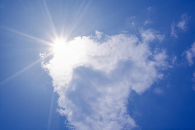 Cielo azul con nubes y la reflexión del sol. El sol brilla brillante durante el día en verano