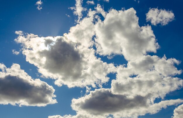 Un cielo azul con nubes y un resplandor solar