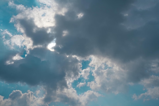 Un cielo azul con nubes y un sol brillando a través de las nubes