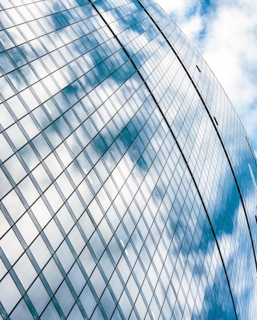 El cielo azul se refleja en una fachada de rascacielos de oficinas