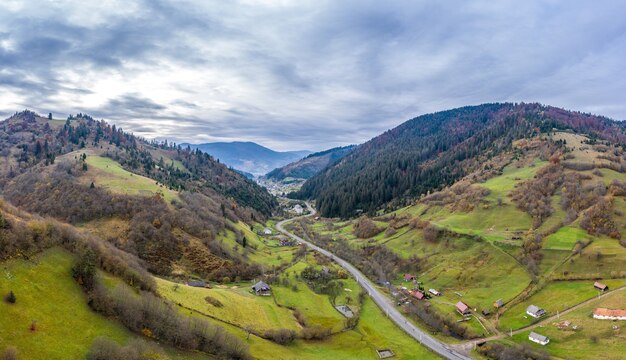 Cielo con capa blanca y esponjosa de nubes sobre verdes colinas otoñales, tiro de drone panorámico aéreo