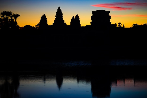 Cielo dramático de Angkor Wat en el amanecer fachada principal silueta reflexión en estanque de agua