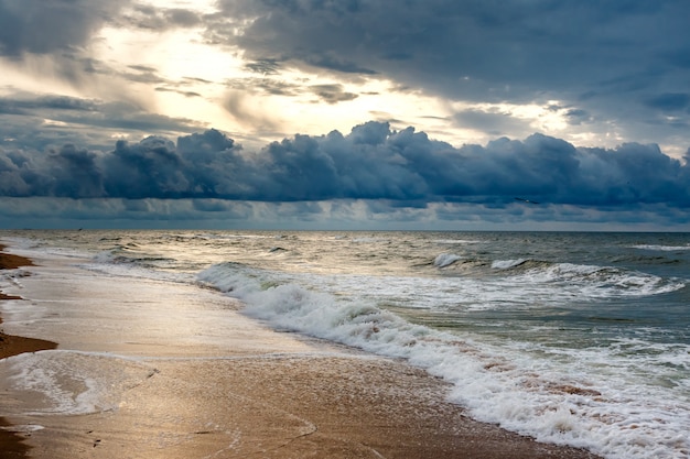 Cielo dramático en un paisaje marino de la mañana. Salida del sol en una playa de arena del mar.