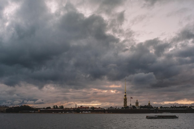 Cielo dramático sobre la fortaleza de Pedro y Pablo en San Petersburgo El barco flota en el río Neva