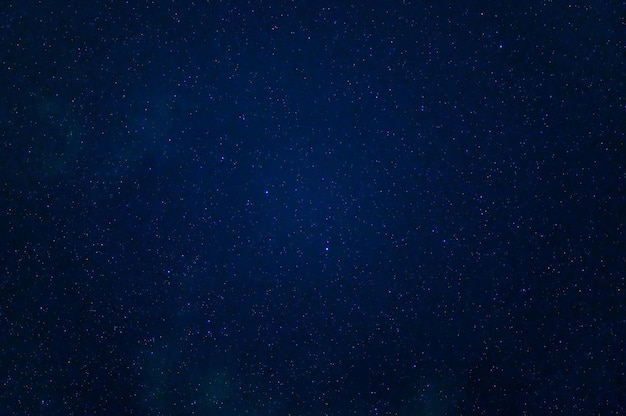 Cielo estrellado con estrellas, la Vía Láctea y la galaxia por la noche sobre un fondo azul oscuro