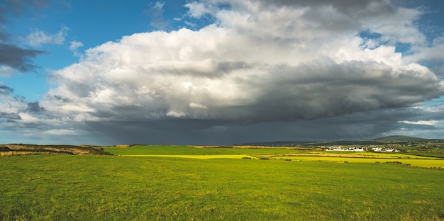 Cielo lluvioso sobre el campo verde. Irlanda del Norte.