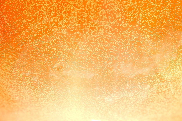 Cielo naranja con muchas partículas brillantes, fondo abstracto. Fondo de pantalla de bombillas de estrellas