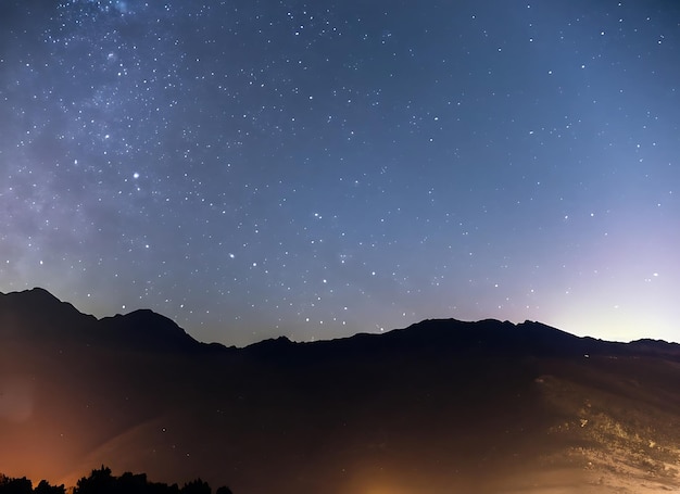 Cielo nocturno con comienzos y fondo de montaña