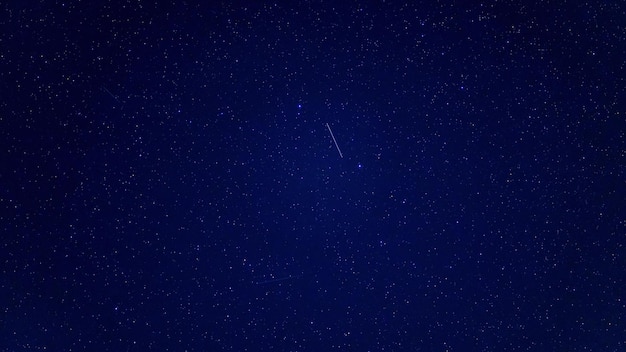 Cielo nocturno estrellado con muchas estrellas brillantes que caen con nubes