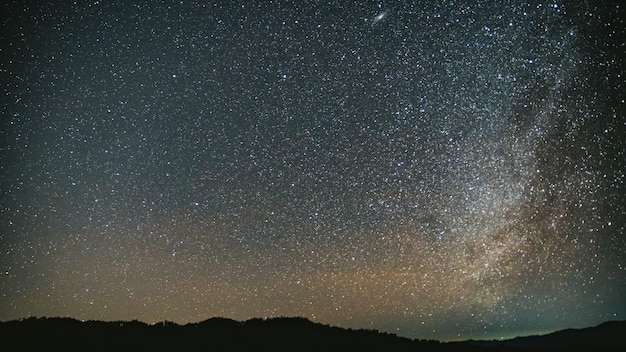 Cielo nocturno con estrellas brillantes y fondo de la Vía Láctea.