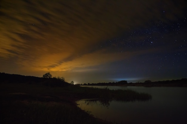 Cielo nocturno nublado sobre el río antes del amanecer.