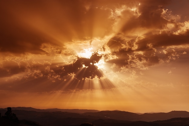 Cielo con nubes y rayos de sol. Puesta de sol sobre las montañas. Tarde de verano Cielo dramático. Hermosa meditación conceptual.