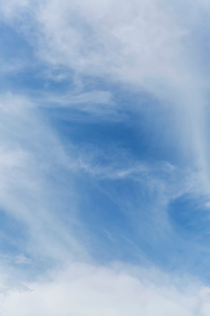 Cielo nublado azul en un día claro y soleado. Fondo. Espacio para texto. Vertical.