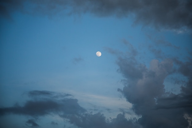 Foto cielo nublado y luna al atardecer.