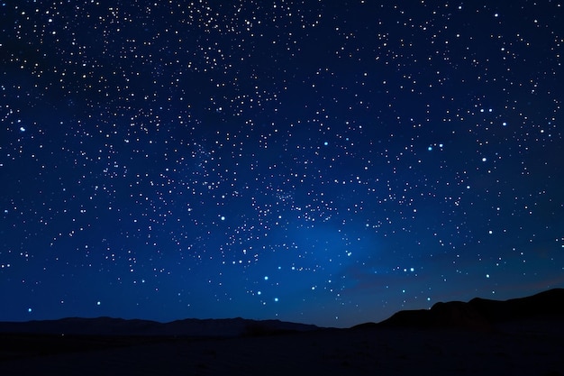 Un cielo oscuro con muchas estrellas y una montaña en el fondo