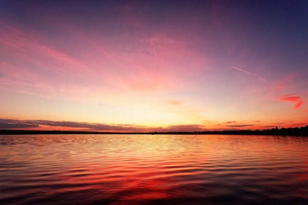 Cielos rosados románticos que se reflejan en un lago tranquilo y sereno