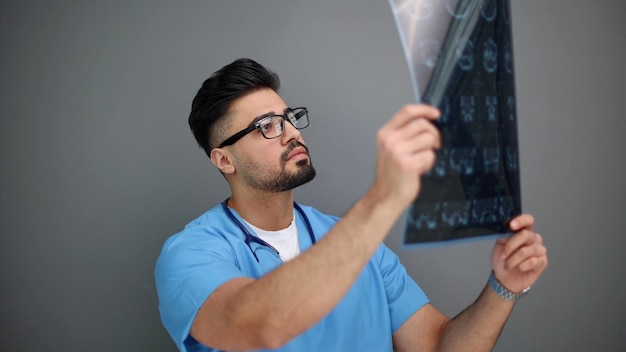 Foto ciência de diagnóstico anatômico do homem especialista examinando filme de raios-x na sala escura do laboratório