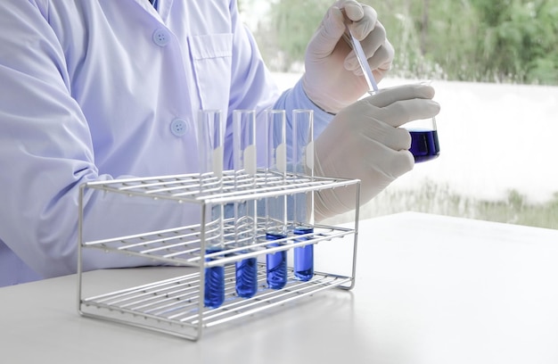 Ciência inovadora Pesquisador de laboratório médico ou científico masculino realiza testes com líquido azul em equipamentos de laboratório tecnologia de experimentos científicos Pesquisa de vacinas Coronavirus Covid19