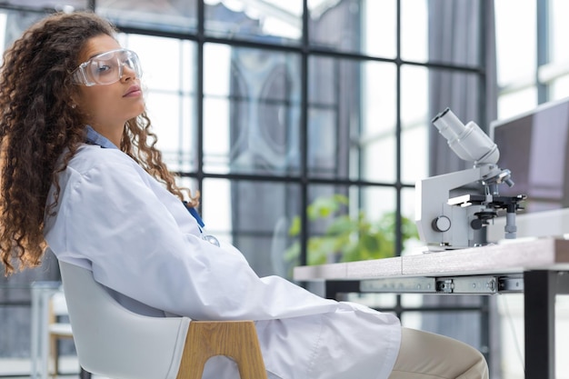 Científica en bata de medicina trabaja en un laboratorio científico