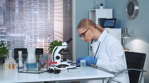 Científica haciendo experimentos con materiales orgánicos en laboratorio de química.