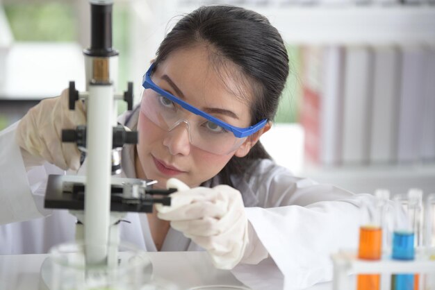 Científica mujer usando el microscopio en el laboratorio