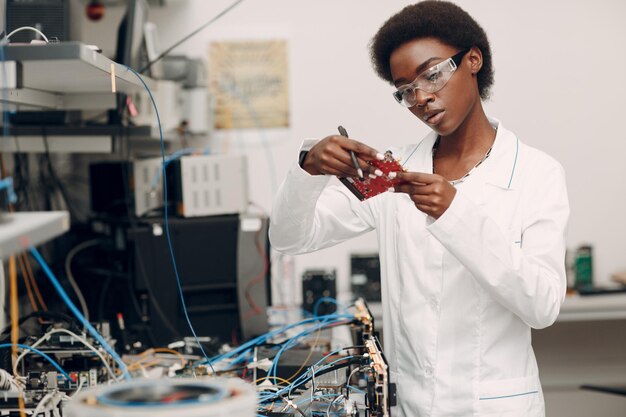 Científico afroamericano que trabaja en laboratorio con instrumentos electrónicos